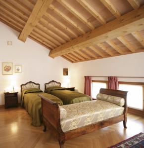two beds in a room with wooden ceilings at Villa Busta Hotel in Montebelluna