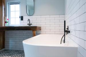 a white bath tub in a bathroom with a sink at Hotel Drei Höfe in Friedrichsdorf