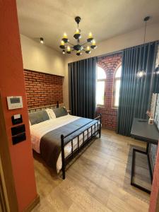 sypialnia z dużym łóżkiem i żyrandolem w obiekcie Hotel Taverna Devolli w mieście Kuçovë