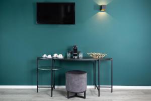 a table with a stool next to a blue wall at Hotel Drei Höfe in Friedrichsdorf