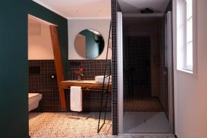 a bathroom with a shower and a sink and a mirror at Hotel Drei Höfe in Friedrichsdorf
