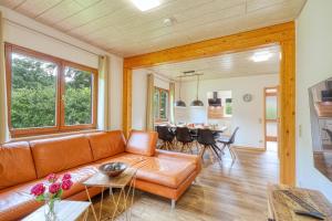 a living room with a couch and a table at Waldblick mit eigener Sauna in Kirchheim