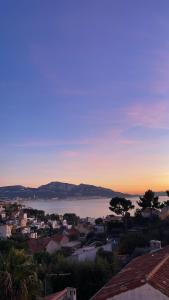 a view of a city and the ocean at sunset at Maï Homes - La Villa Bompard in Marseille