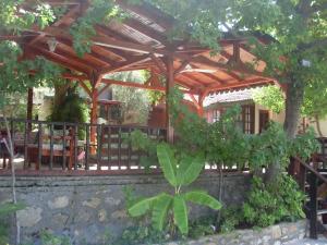 a wooden pergola with a tree and a fence at Onder Pansiyon in Dalyan