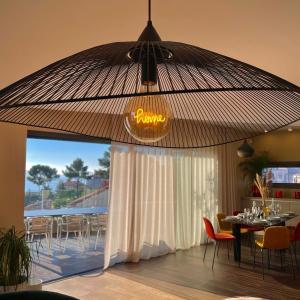un restaurant avec un grand parasol, une table et des chaises dans l'établissement Maï Homes - La Villa Bompard, à Marseille