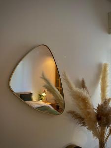 a mirror on a wall with a lamp and a plant at Maï Homes - La Villa Bompard in Marseille