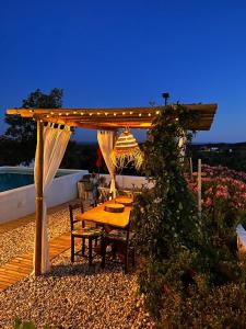 a wooden table and chairs under a pergola at Monte Refúgio do Silêncio in Portalegre