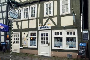 ein Gebäude mit weißen Türen und Fenstern auf einer Straße in der Unterkunft Bavaria Wirtshaus - Hotel & Gästezimmer- Frankenberg Eder in Frankenberg