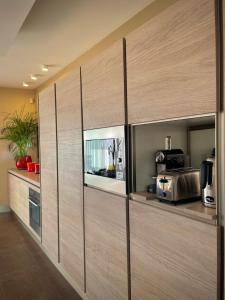 a kitchen with wooden cabinets with a tv in it at Maï Homes - La Villa Bompard in Marseille