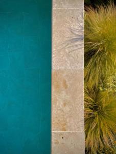 two pictures of a pool with grass next to it at Maï Homes - La Villa Bompard in Marseille