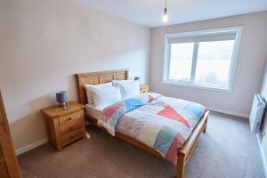 um quarto com uma cama e uma janela em Etive, Beautiful Lochside Apartment with balcony em Fort William