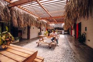 un homme et une femme assis sur un banc dans un patio dans l'établissement Makenke Hostel By Los Colores Ecoparque, à Doradal