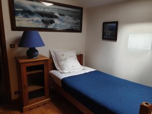 a small bedroom with a bed and a lamp at La GRANGE de MOMBEL in Losse