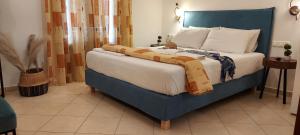 a bedroom with a large bed with a blue headboard at Apartments Anna Maria in Agia Anna Naxos