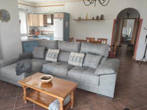 a living room with a gray couch and a table at Casa rural Villa Miradri in Torrox