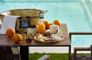 a plate of food on a table with oranges and juice at Volta Suites and Villas in Gouves