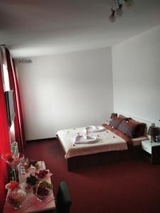Motel/Hostel Dreams في Novi Travnik: غرفة نوم بسرير وطاولة عليها طعام