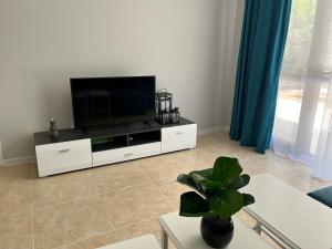 a living room with a flat screen tv on a white entertainment center at TM Panorama Beach Apartments in Nesebar