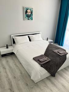a bedroom with a large white bed with two tables at TM Panorama Beach Apartments in Nesebar