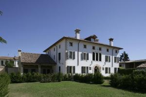 ein großes weißes Haus mit einem Dach in der Unterkunft Villa Busta Hotel in Montebelluna