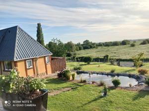 dom ze stawem na podwórku w obiekcie Gîte du roy w mieście Marais-Vernier