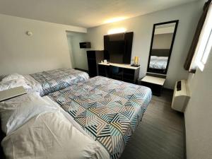 a hotel room with two beds and a mirror at Motel 6-Council Bluffs, IA - Omaha East in Council Bluffs