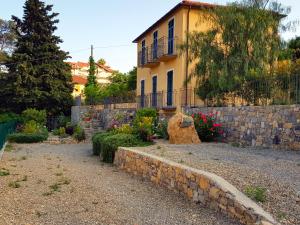 ein Haus mit einer Steinwand und einem Hof in der Unterkunft Casa Laura in Imperia