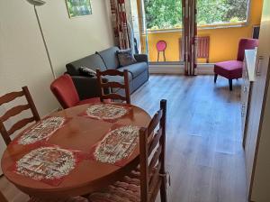 a living room with a table and chairs and a couch at Appartement classé 3 étoiles SAINT-LARY in Saint-Lary-Soulan