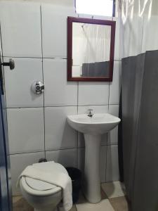 bagno con lavandino, servizi igienici e specchio di Pousada Estrada Real a Milho Verde