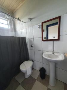 a bathroom with a sink and a toilet and a mirror at Pousada Estrada Real in Milho Verde