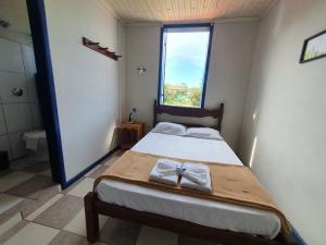 a bedroom with a bed with a cross on it at Pousada Estrada Real in Milho Verde