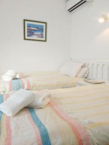 - 2 lits dans une chambre blanche avec une photo sur le mur dans l'établissement AP361 - Carabeo 78, à Nerja