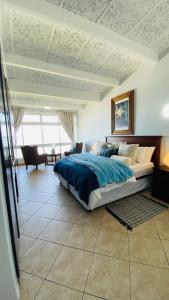een slaapkamer met een groot bed en een blauwe deken bij Sea View Luxury Penthouse in Ballito