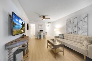 uma sala de estar com um sofá e uma televisão em Beach Apart By Pmi Unit 2 em West Palm Beach