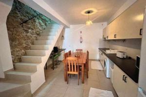 a kitchen and dining room with a staircase and a table at Casa de Santa Maria 113 in Castelo Branco