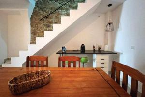 a dining room with a table with chairs and a staircase at Casa de Santa Maria 113 in Castelo Branco