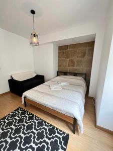 a bedroom with a bed and a black and white rug at Casa de Santa Maria 113 in Castelo Branco