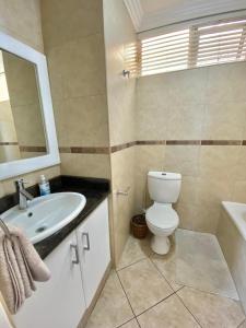 een badkamer met een wit toilet en een wastafel bij Sea View Luxury Penthouse in Ballito