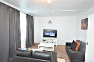 a living room with a couch and a tv at Beautiful Two Bedroom Flat in Brixton London in London