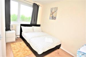 a small bedroom with a bed and a window at Beautiful Two Bedroom Flat in Brixton London in London