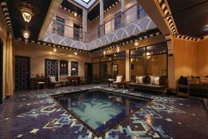 Riad Bindoo & Spa في مراكش: مسبح داخلي في منزل به سقف