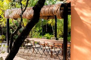 drewniany stół i krzesła pod drzewem w obiekcie La Jacaranda w mieście Hornachuelos