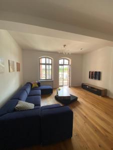 uma sala de estar com um sofá azul e uma mesa em Loft in bester Lage em Landau in der Pfalz