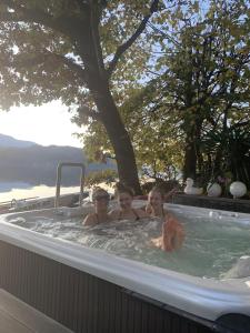 drie kinderen baden in een jacuzzi met een boom bij Seefels Appartements in Döbriach