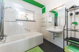 bagno con vasca bianca e lavandino di Seefels Appartements a Döbriach