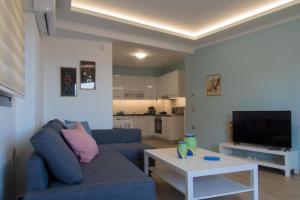 ein Wohnzimmer mit einem Sofa und einem Tisch in der Unterkunft Chelidoni apartment ground floor in Iraklio