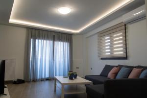 een woonkamer met een bank en een tafel bij Chelidoni apartment ground floor in Heraklion