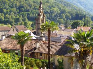 a small town with palm trees and a church at Chalet des noisetiers in Seix