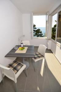 a dining room with a table and two chairs at Villa Dalmatia Apartments in Brela