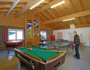 a man standing in a room with pool tables at Landhotel Kielhuberhof in Ramsau am Dachstein